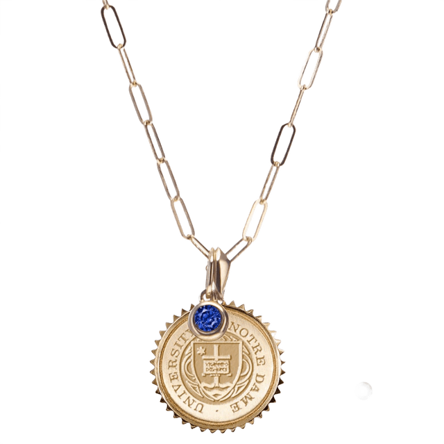 Necklace pendant with intricate engraving near the Notre Dame seal.